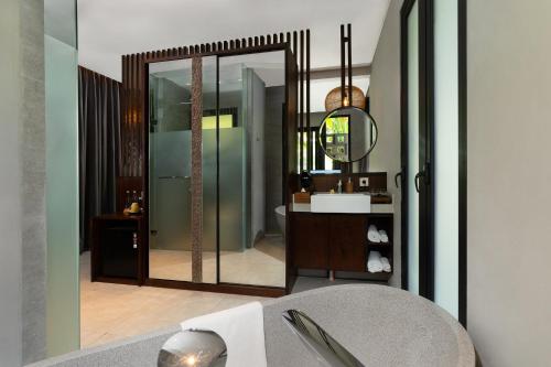 a bathroom with a sink and a mirror at The Ning Resort Ubud in Ubud