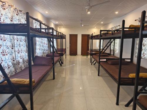a row of bunk beds in a room at The Rishi Van Dormitory, Khetri,Rajasthan,Farm No 52-55,Vally Drive,Retreat Nature Farms Society Complex in Khetri