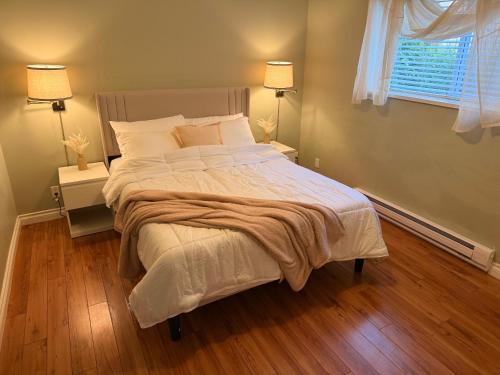 a bedroom with a large bed with white sheets and pillows at Spacious 2 Bedroom Suite in Delta