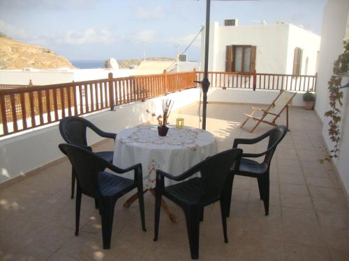 a table and chairs on a balcony with the ocean at Sarris Studios & Apartments in Líndos