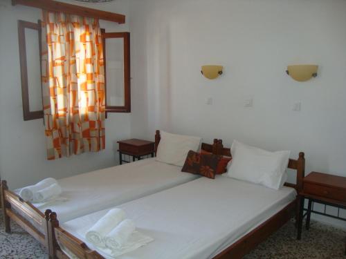 a bedroom with two beds and a window at Sarris Studios & Apartments in Lindos