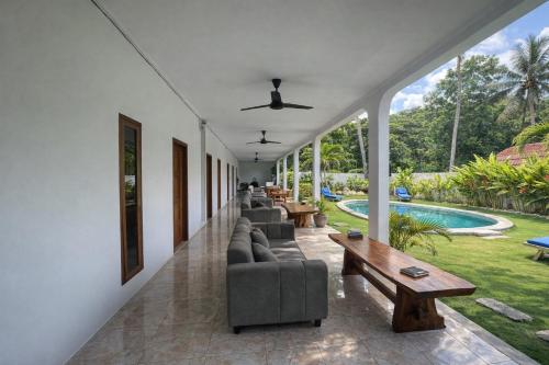 a living room with couches and a table and a pool at Wanderlust Hostel - Highest Privacy Hostel In Kuta - Big Clear Pool - Fast Internet in Kuta Lombok