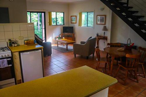 a kitchen and a living room with a table and chairs at LAKE VIEW CHALET Australia Zoo close by in Landsborough