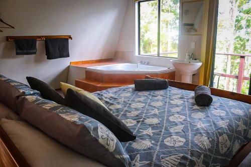 a bedroom with a bed and a bath tub at LAKE VIEW CHALET Australia Zoo close by in Landsborough