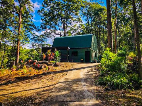 a green building in the middle of a forest at LAKE VIEW CHALET Australia Zoo close by in Landsborough