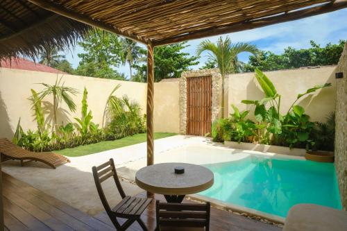 a patio with a table and chairs next to a swimming pool at Nala Villas in General Luna