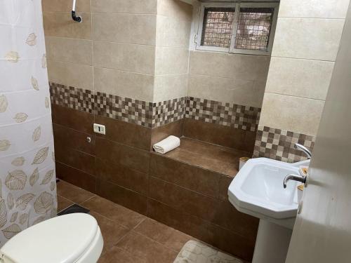 a bathroom with a toilet and a sink at beit al moukhtar in Ḩārat at Taḩtā