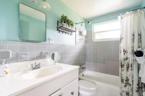 a bathroom with a sink and a toilet and a mirror at Lemon Bay Hideaway, Retro Beach Bungalow in Venice