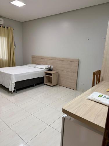 a room with a bed and a table in it at Plaza Hotel in Mineiros