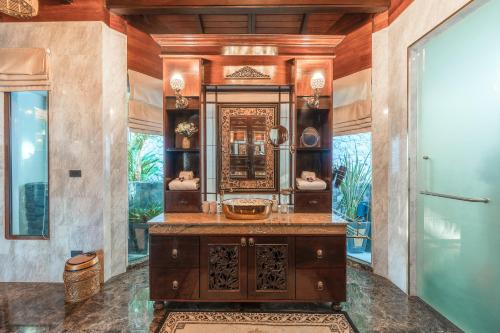 a bathroom with a sink and a mirror at Arun Rapee Villa Surin Beach in Surin Beach