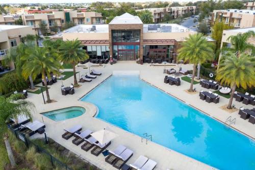 an overhead view of a pool with chairs and palm trees at Stunning 4Bd Close to Disney @ Magic Village 7614 in Orlando