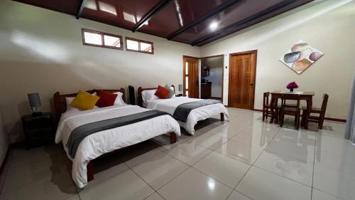 a bedroom with two beds and a table in it at Chirripó Oasis in Canaán
