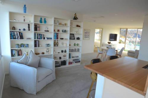 a living room with a white book shelf with books at Prime Luxury Penthouse Living in Launceston