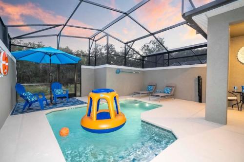 an indoor pool with an inflatable raft in a house at Wonderful 5 Bd w Pool @ Storey Lake Resort 2545 in Kissimmee