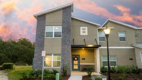 a house with a sunset in the background at Wonderful 5 Bd w Pool @ Storey Lake Resort 2545 in Kissimmee