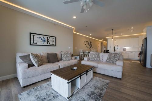 a living room with two couches and a kitchen at Wow Where Dreams become Reality New Luxury Unit in Osage Beach
