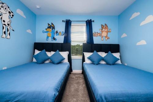 two beds in a room with blue walls at Marvelous 4Bd with Pool at Storey Lake Resort 2601 in Kissimmee