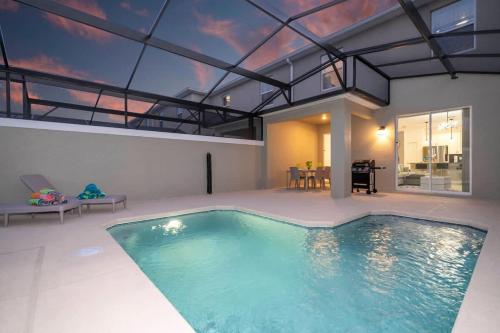 a swimming pool in a house with a glass ceiling at Marvelous 4Bd w Pool Close to Disney at Storey Lake 2629 in Kissimmee