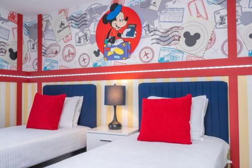 a bedroom with two beds with red pillows at Charming 4Bd w Private Pool @ Storey Lake Resort 2653 in Kissimmee