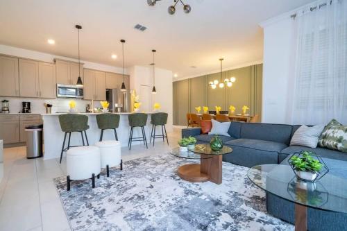 a living room with a blue couch and a kitchen at Charming 4Bd w Private Pool @ Storey Lake Resort 2653 in Kissimmee