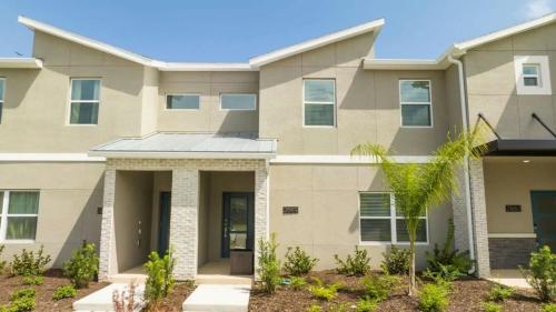 a house with a palm tree in front of it at WonderFul 4Bd w Pool Close to Disney at StoreyLake 2669 in Kissimmee