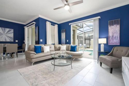 a living room with blue walls and a couch and a table at Fantastic 4 Bd w Pool at Storey Lake Resort 2709 in Kissimmee