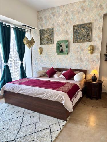a bedroom with a large bed with red pillows at Royal Moroccan Escape in Noida in Noida