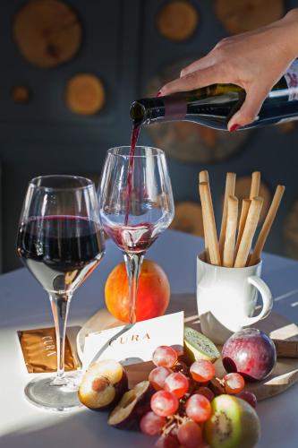 a person pouring wine into a wine glass at Hotel Cura in Canakkale