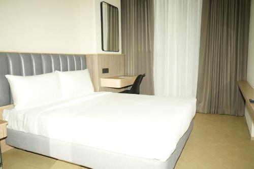 a large white bed in a hotel room at APL Residency by Darling in Vishāram