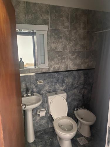 a bathroom with a toilet and a sink at El Remanso de Paracao in Paraná