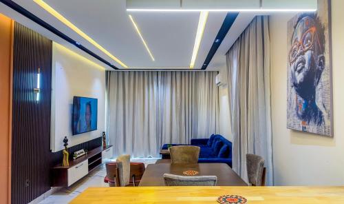 un soggiorno con un tavolo e un divano blu di Residence Ayoka a Cotonou