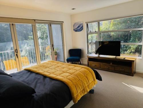 a bedroom with a bed and a desk and a television at Villa Sebastian - Large Modern Home in Wellington