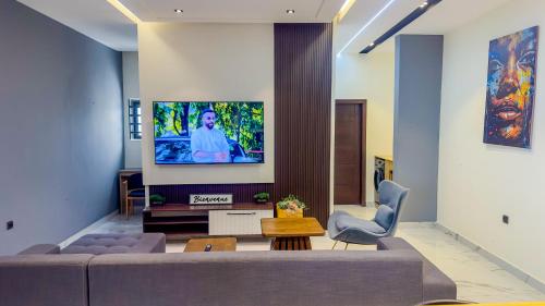 un soggiorno con un divano e una TV su una parete di Residence Ayoka a Cotonou