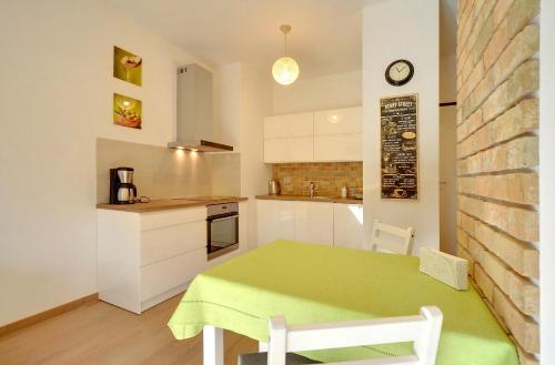 a small kitchen with a green table and a counter at Apartament Wille Parkowe in Polanica-Zdrój