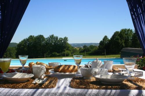 a table with a table cloth with food on it at La Rolandie Haute in Limeuil
