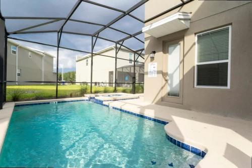 a swimming pool in front of a house at Stunning Family Friendly 5 Bd w/ Pool Close to Disney @ Storey Lake 4242 in Kissimmee
