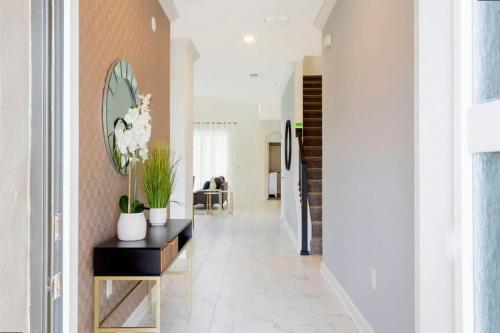 a hallway with a console table and a mirror at Stunning Family Friendly 5 Bd w/ Pool Close to Disney @ Storey Lake 4242 in Kissimmee