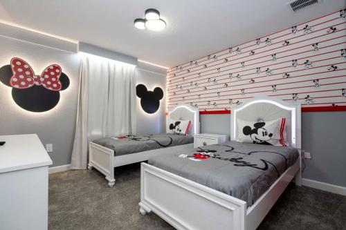 a bedroom with two beds and a wall with butterflies at Gorgeous 4Bd with Pool at Storey Lake Resort 4475 in Kissimmee
