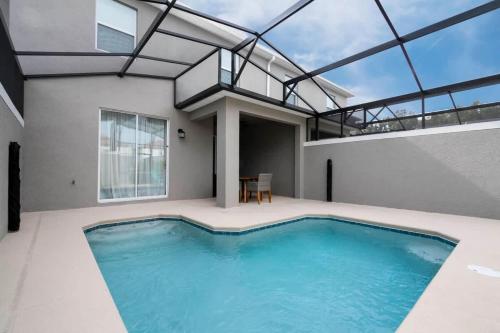 a swimming pool in a house with a glass ceiling at Gorgeous 4Bd with Pool at Storey Lake Resort 4475 in Kissimmee