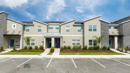 a large apartment building with a parking lot at Gorgeous 4Bd with Pool at Storey Lake Resort 4475 in Kissimmee