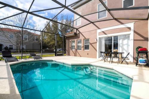a swimming pool in front of a house at Four Bedroom w/ Screened Pool Close to Disney 4572 in Kissimmee