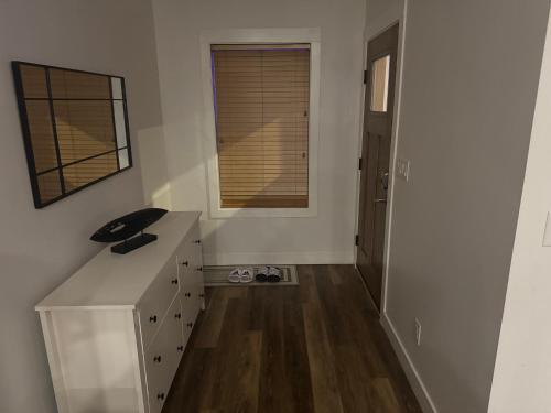 a white room with a desk and a window at Next rental in Vernon