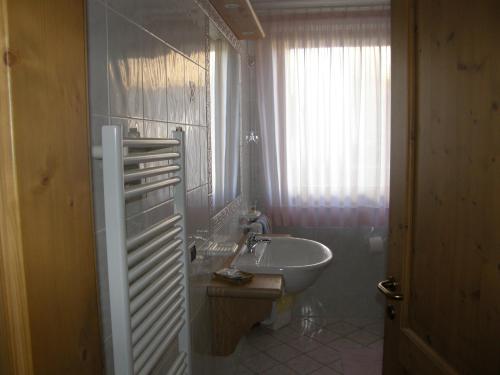 uma casa de banho com um lavatório, um WC e uma janela. em Villa Ilaria em Caderzone