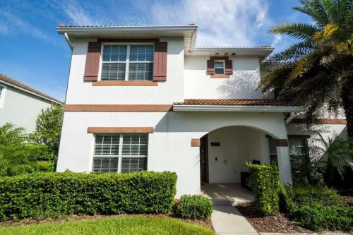 a white house with a palm tree at Five Bedrooms TownHome with Pool 4849 in Kissimmee