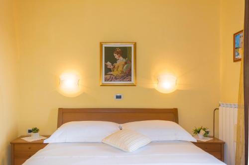 a bedroom with a bed with two lamps on the wall at Guesthouse Villa Marija in Motovun