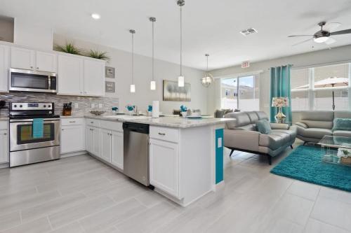 a kitchen with white cabinets and a living room at Four Bedroom with GameRoom 5150A in Kissimmee