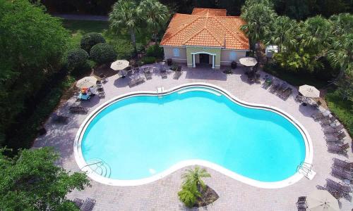 an overhead view of a swimming pool with chairs and umbrellas at Four Bedroom with GameRoom 5150A in Kissimmee