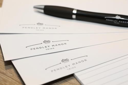 a pen sitting on top of two white envelopes at Pendley Manor in Tring