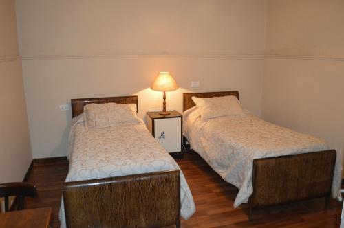 two beds in a room with a lamp on a table at Hotel Mallorca in Mendoza