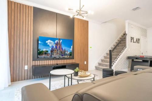 a living room with a tv on a wall at Stunning 5 Bd w Pool at Storey Lake Resort 2400 in Kissimmee